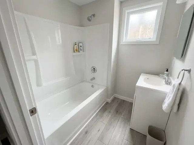 Bathroom with a new white tub and shower surround (illustration)