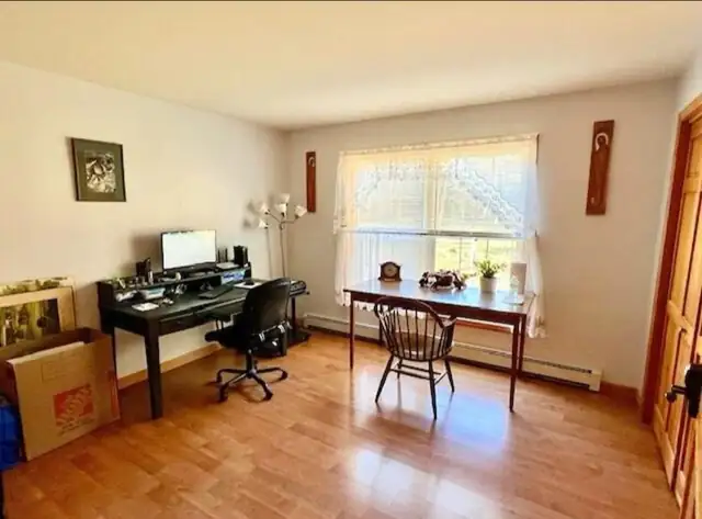 Home office with wood floor, a desk and a window